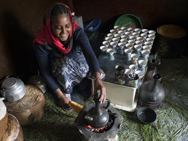 Woman making coffee over a fireplace