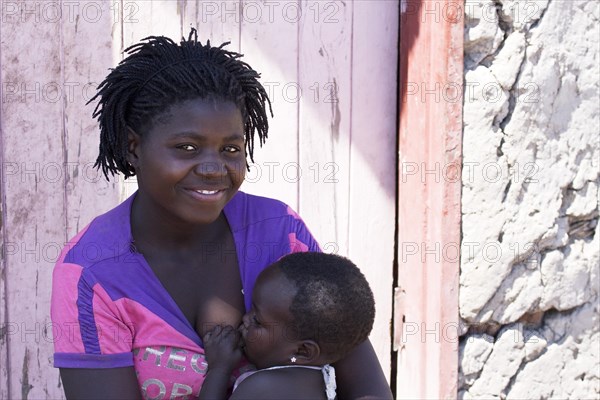 Breastfeeding mother with child in a village near the Tsodilo Hills