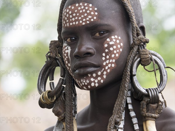 Girl of the Mursi tribe with headdress and face painting