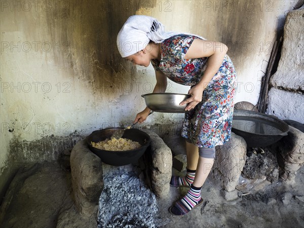 Young woman preparing rice dish Plov