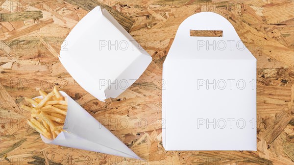 French fries paper cone white package wooden background