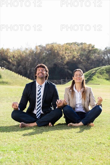 Cheerful businesspeople lotus position