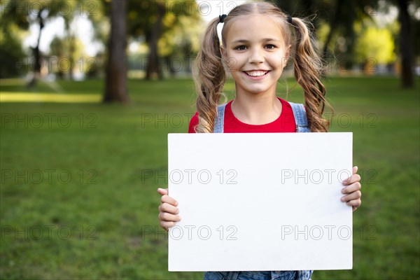 Happy girl holding empty banner her hand