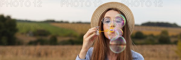 Woman outdoors making soap bubbles