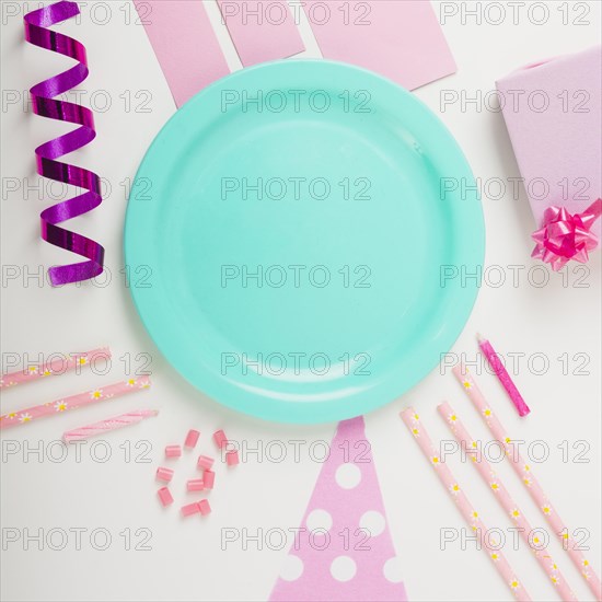 Overhead view plate surrounded with decorative items white backdrop