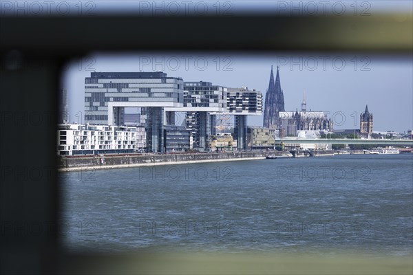 View of the city of Cologne and the Rhine through the railing of the South Bridge with Rheinauhafen