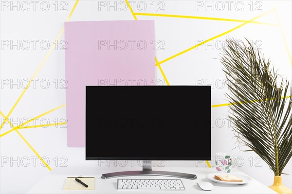 Creative workplace with monitor palm leaf