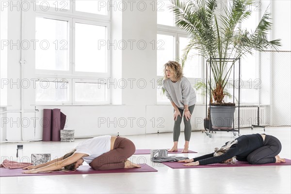 Teacher watching women stretching