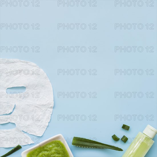Close up aloevera face mask spray bottle leaf blue background