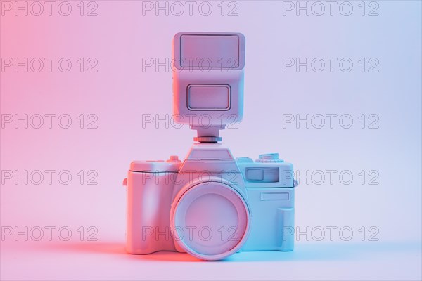 Blue light vintage painted pink camera against pink backdrop