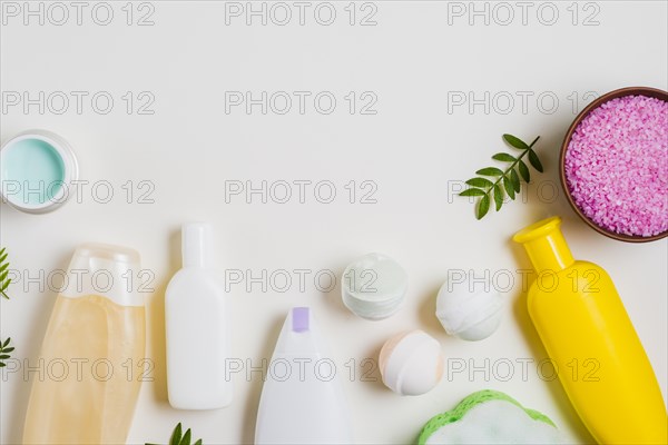 Cosmetic products with bath bomb pink salt cream white backdrop