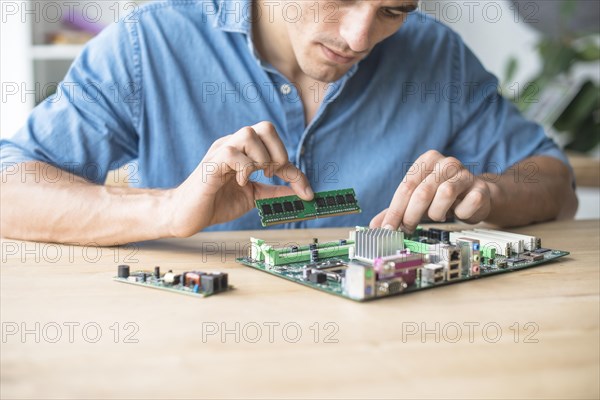 Technician inserting ram socket computer motherboard