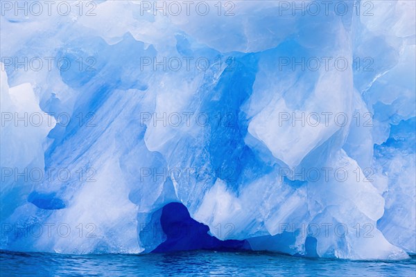 Ice cave in a iceberg floating in the sea at arctic