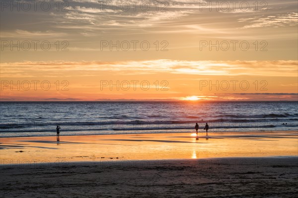 Atlantic ocean sunset with photographer silhouette taking images of surging waves at Fonte da Telha beach