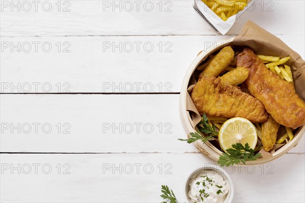 Top view fish chips bowl with lemon