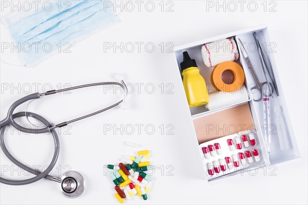 Colorful capsules stethoscope mask with first aid kits white background