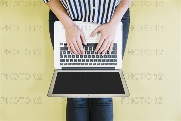 Crop woman browsing laptop floor