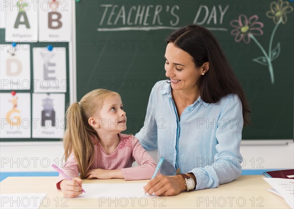 Teacher looking her little student