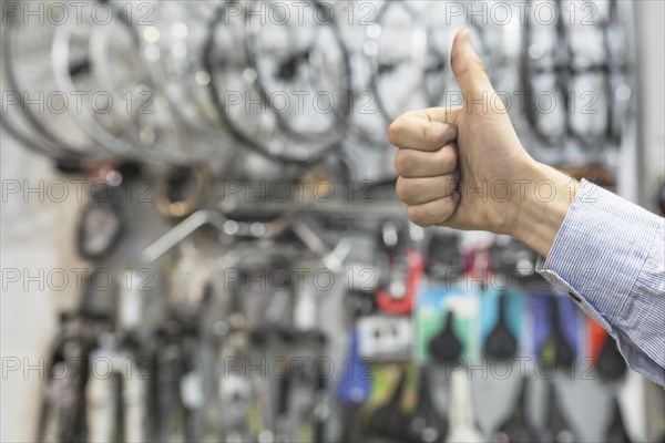 Male mechanic gesturing thumbs up bicycle workshop