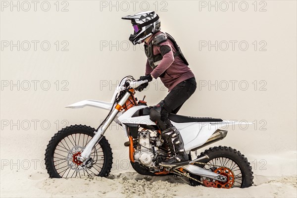 Stylish man riding motorbike desert