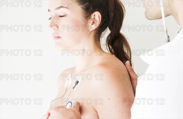 Doctor with stethoscope checking respiration lady