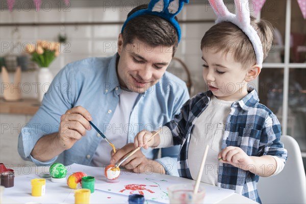 Father son painting eggs easter together