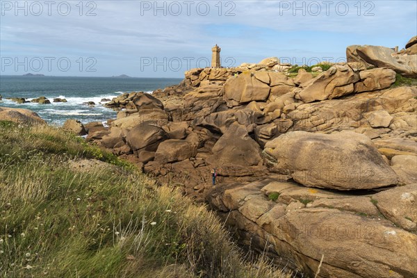 The rocks of the pink granite coast Cote de Granit Rose and the lighthouse Phare de Ploumanac'h near Ploumanac'h