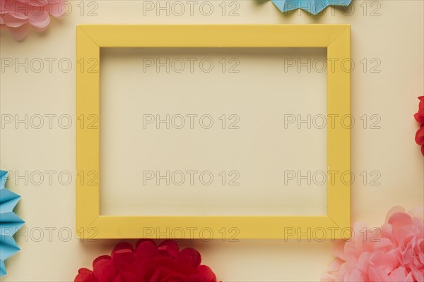 Yellow wooden border picture frame with decorated origami flowers
