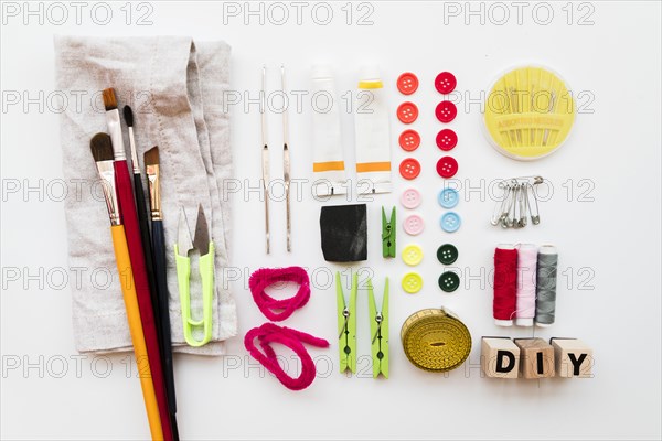 Diy equipment paintbrush clothespin needle safety pins acrylic paint tube buttons diy blocks measuring tape isolated white backdrop