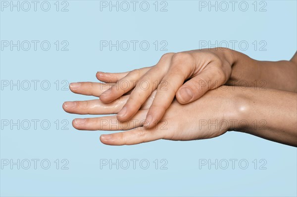 Sideways woman washing hands isolated blue