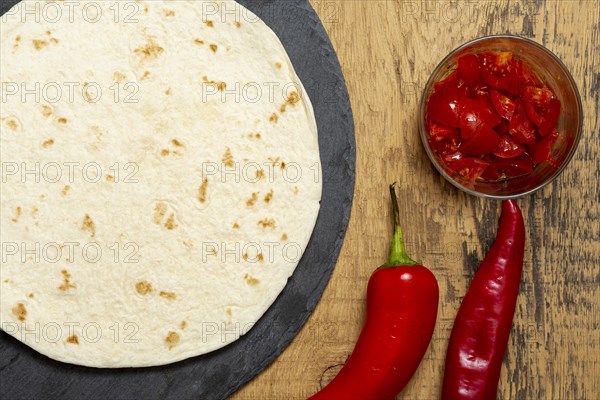 Tortilla near pepper sliced tomatoes