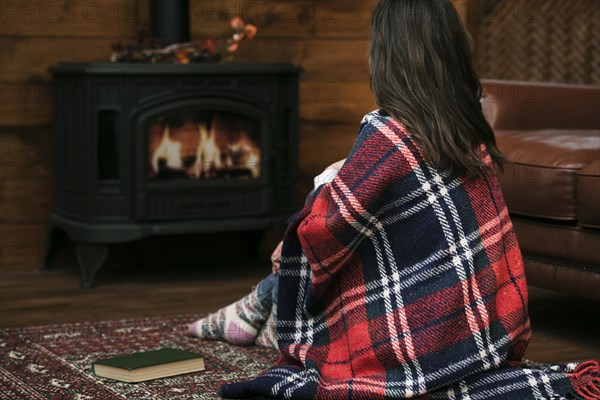 Woman covered blanket fireplace