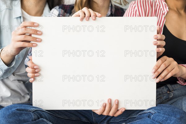 Big white sheet paper holding by women