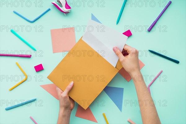 Female hand removing card from envelope stationery accessories