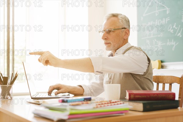 Old teacher pointing classroom