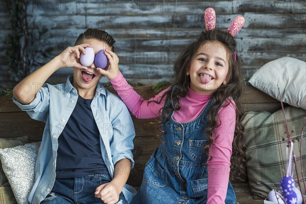 Girl boy with easter eggs making faces