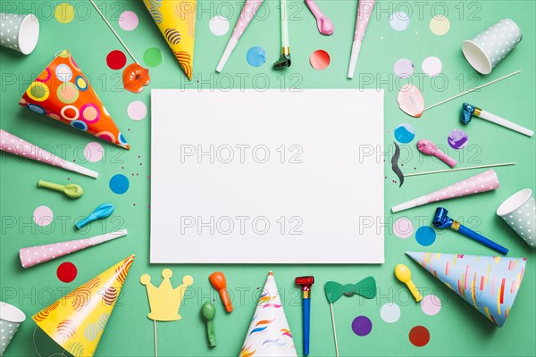 Blank white card decorated with birthday items confetti green background