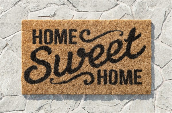 Overhead of home sweet home doormat on the rock tile porch