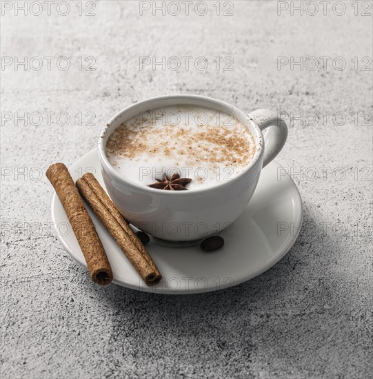 High angle coffee cup with cinnamon sticks star anise