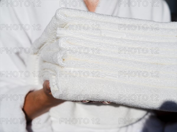 Woman holding white folded clean towels