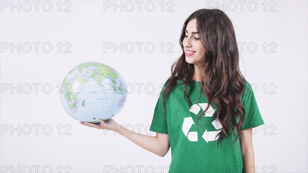Smiling young woman looking globe