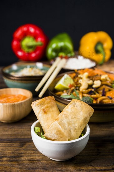 Fried spring rolls white bowl with thai food wooden desk