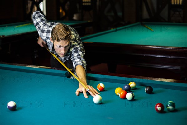 Medium shot guy with pool cue billiard table