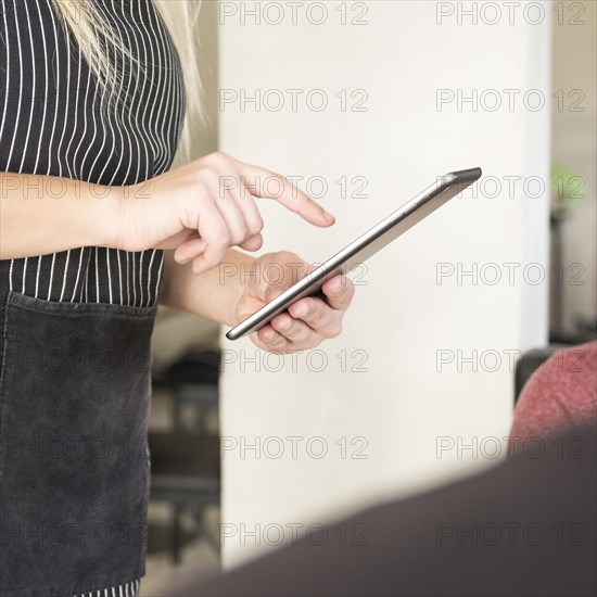 Close up waitress using digital tablet