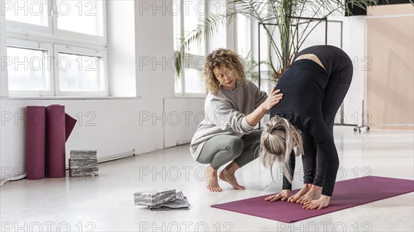 Woman doing yoga with teacher