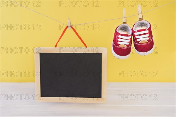 Baby concept with slate shoes hanging clothesline