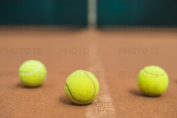 Three green tennis balls tennis court