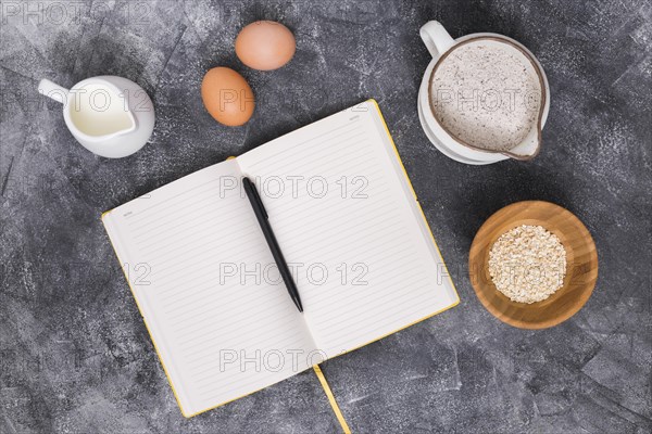 Bread ingredients with book pen concrete backdrop