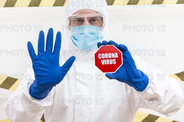 Man hazmat suit with coronavirus stop sign