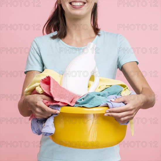 Smiley woman holding laundry basket